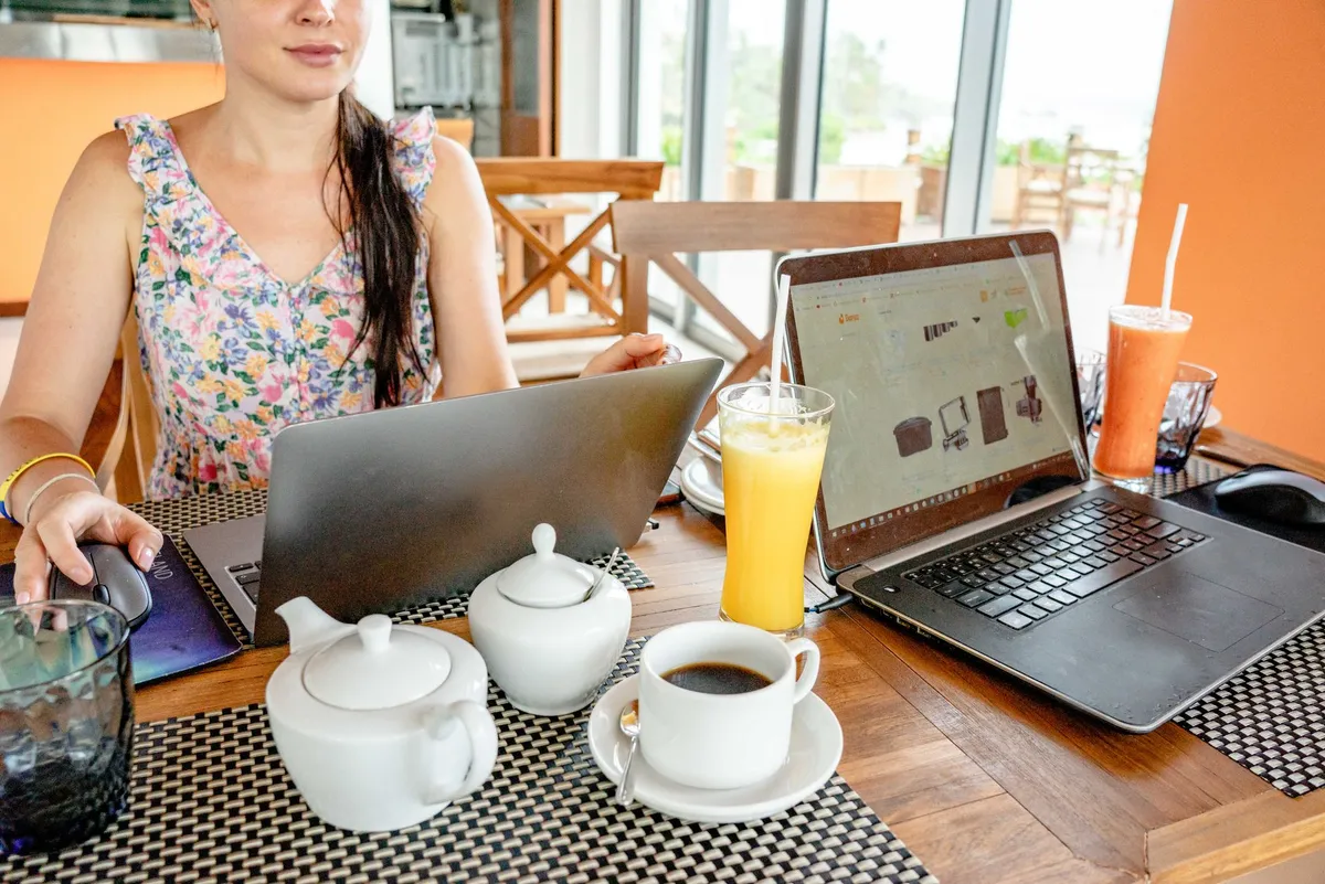 Digital nomad working on laptop at beachfront café
