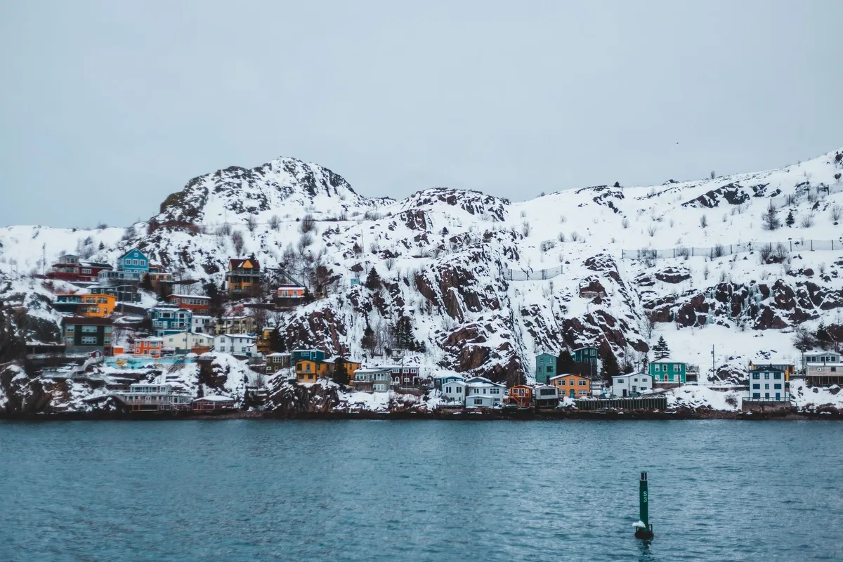 Svalbard town with colorful houses against snowy mountains