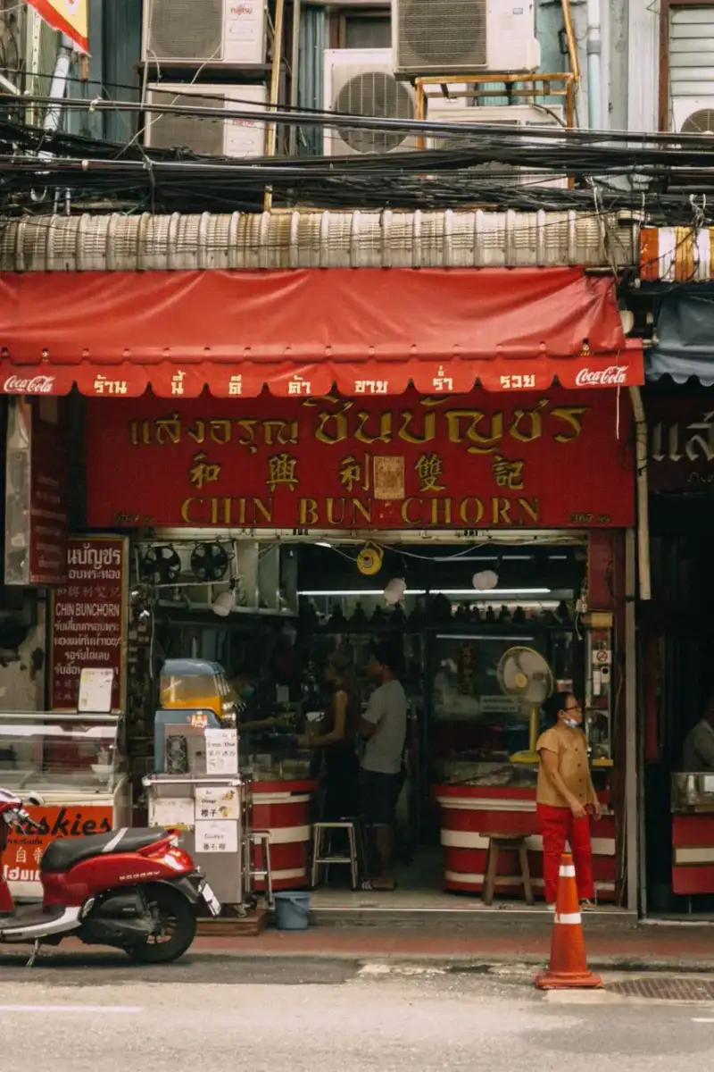 A vibrant Bangkok street food stall with sizzling woks and steaming bowls