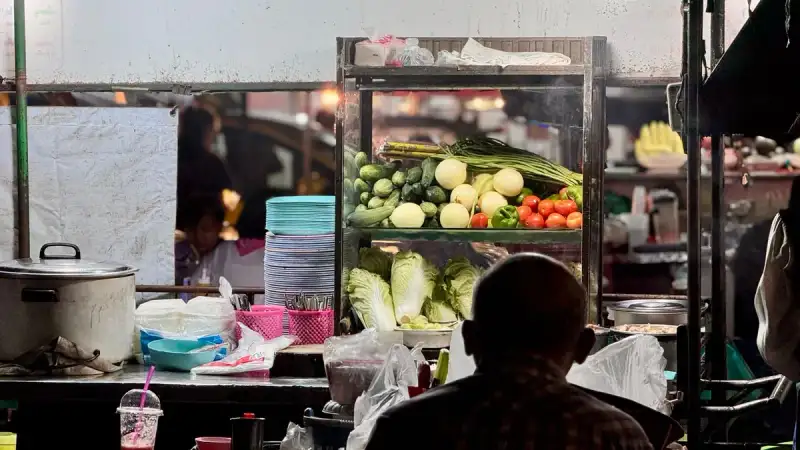 A traditional Chiang Mai street food stall with sai oua and khao soi
