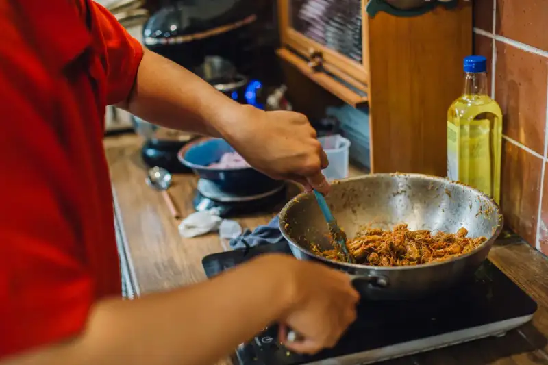 A close-up of a chef stir-frying pad thai in a wok