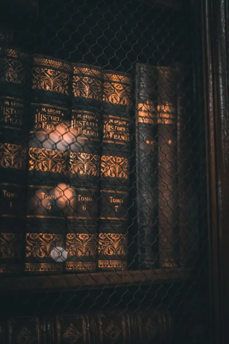 An open ancient book resting on a wooden study table