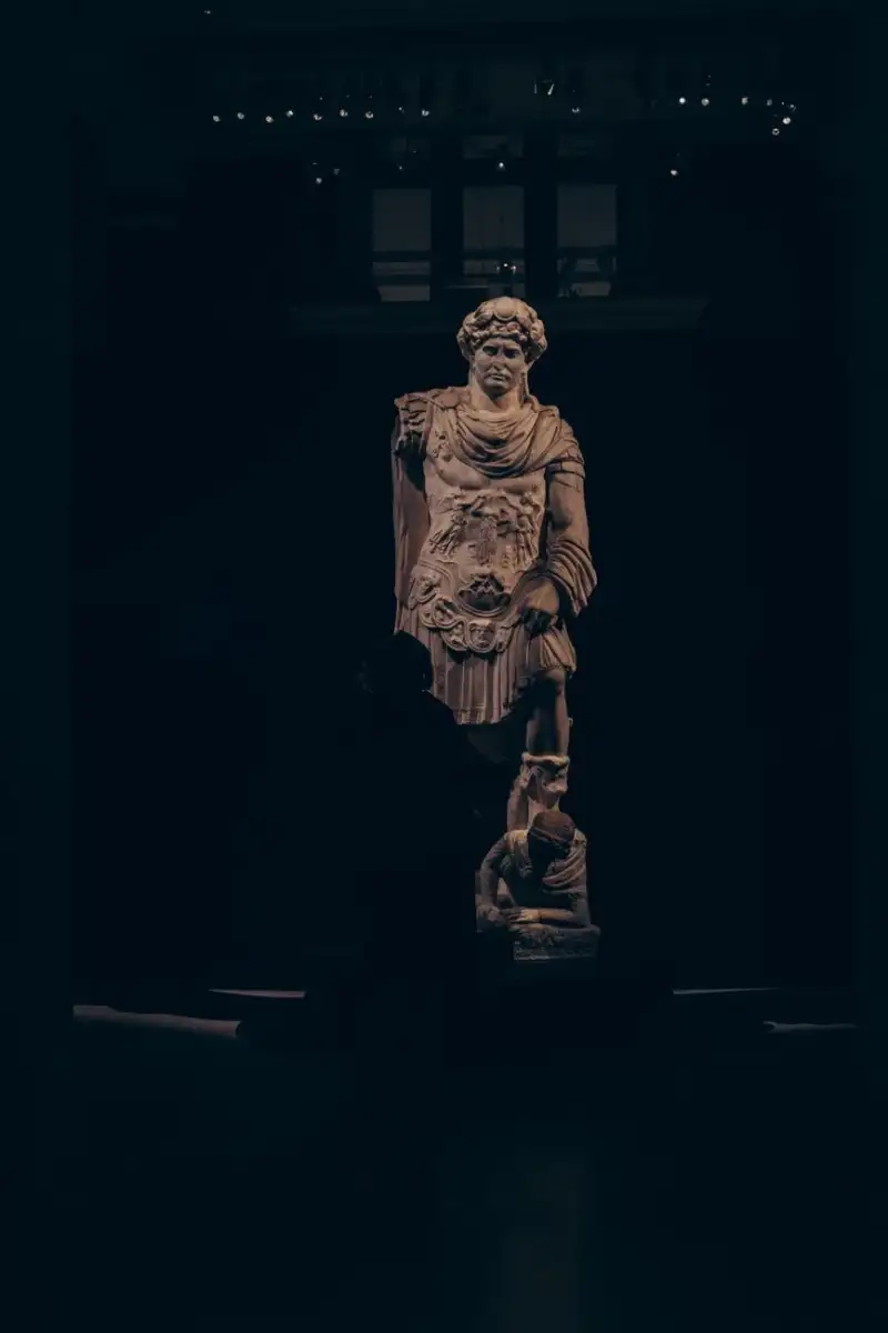 A classical stone sculpture in a dimly lit hall