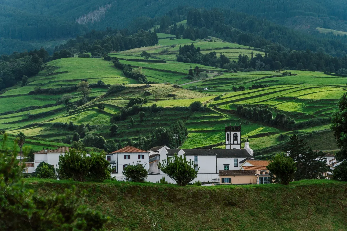 Lush green landscape with a traditional windmill in the Azores