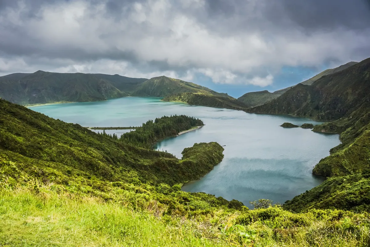 Sunset over a volcanic crater lake with mist rising from the water