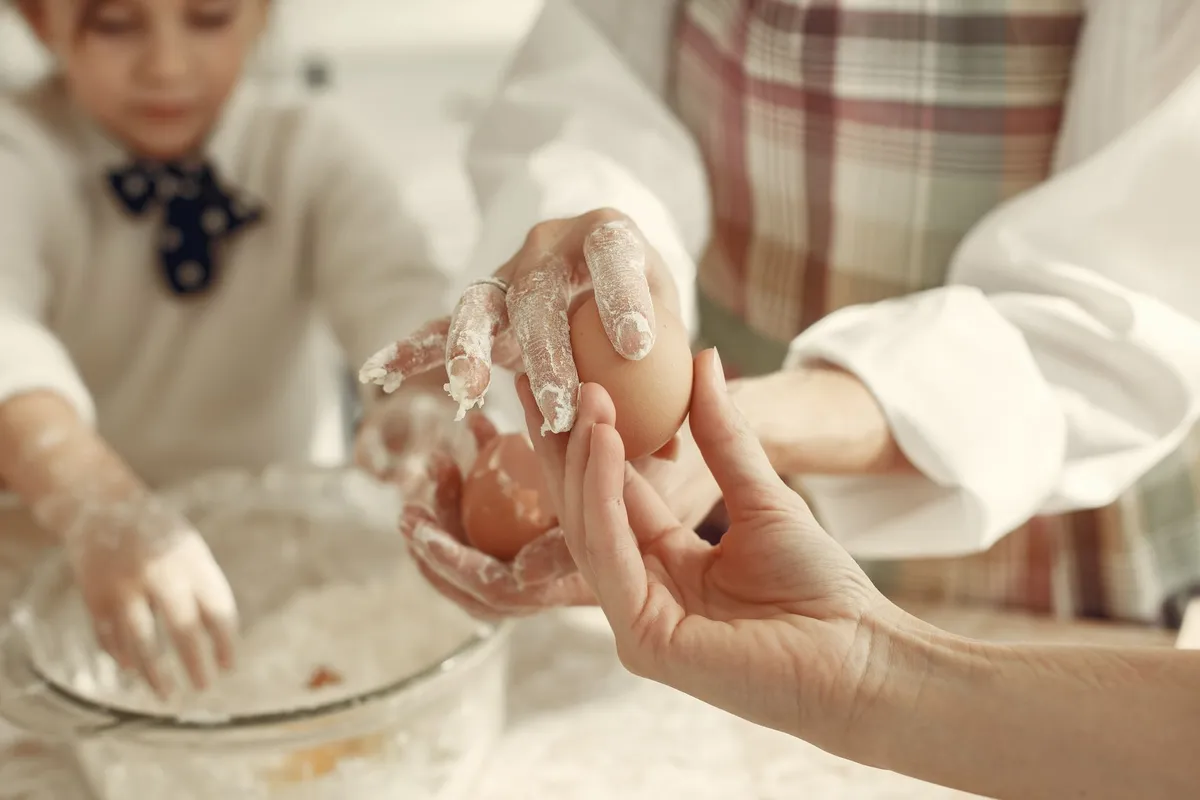 A professional kitchen scene showing the final assembly of a shepherd's pie before entering the oven.