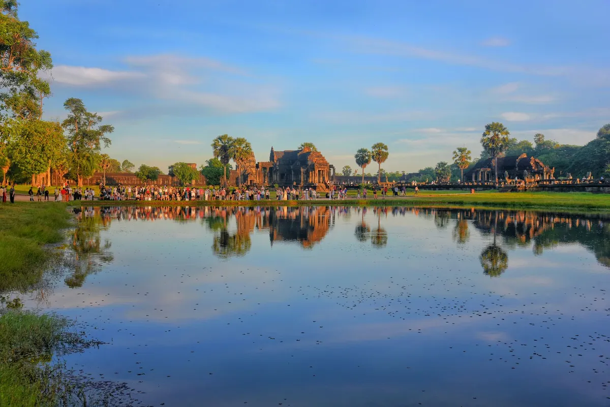Sunrise over Angkor Wat with tourists in silhouette