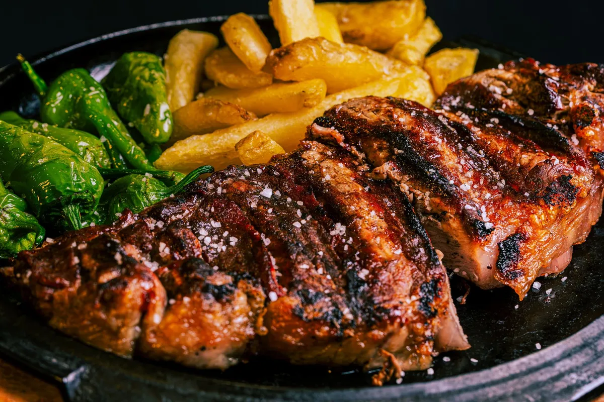A close-up of a grilled steak with a caramelized crust, showcasing the Maillard reaction and umami-rich sear