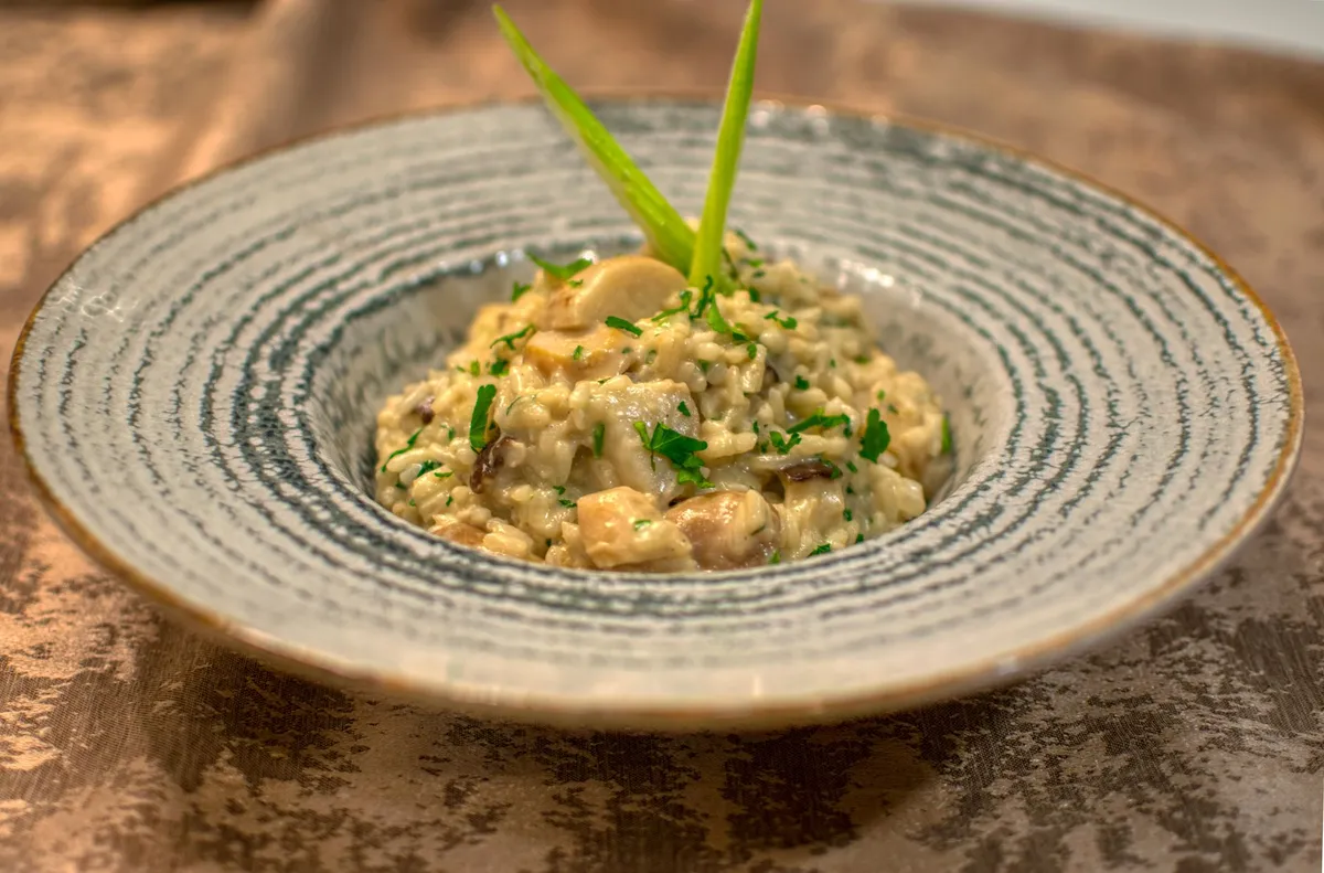 A bowl of creamy mushroom risotto with a sprinkle of truffle shavings, showcasing layered umami flavors