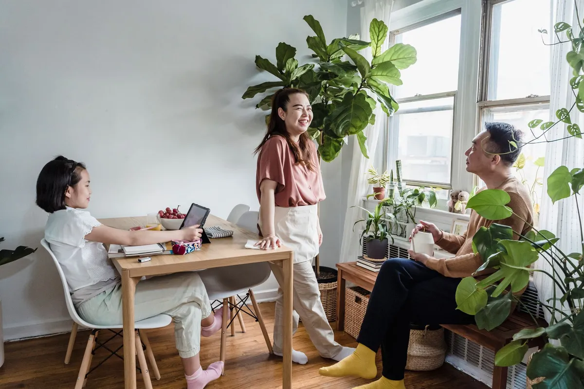 A family gathered around a table, each holding a cup of chai, smiling and engaging in conversation