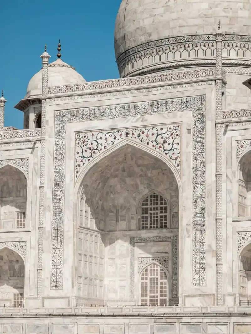 The iconic facade of the Taj Mahal, highlighting its intricate marble work and grand archways
