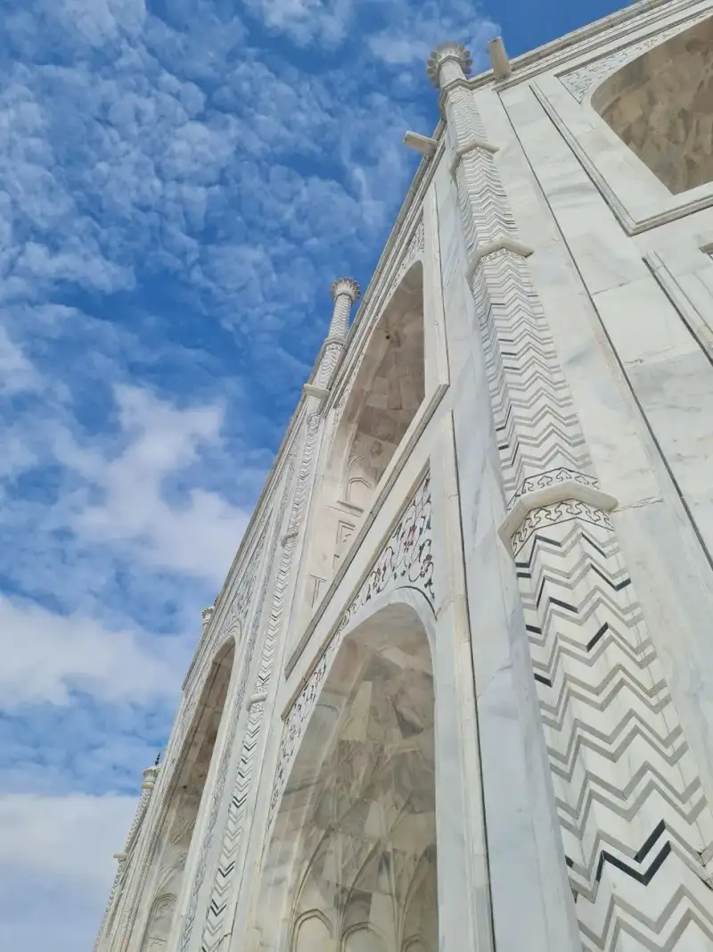 A close-up view of the intricate floral patterns and semi-precious stone inlay on the Taj Mahal's marble facade