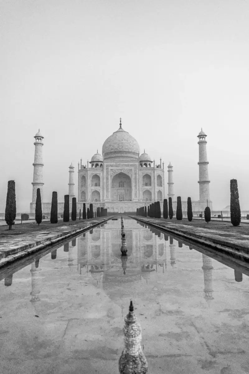 The Taj Mahal reflected in its majestic central pool, showcasing its perfect symmetry and serene beauty