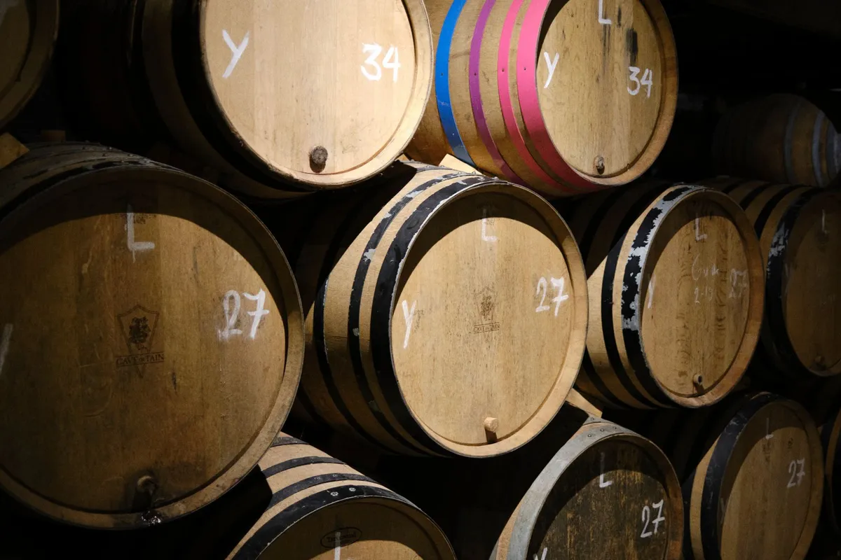 Wooden barrels stacked in a dark miso storehouse aging for years