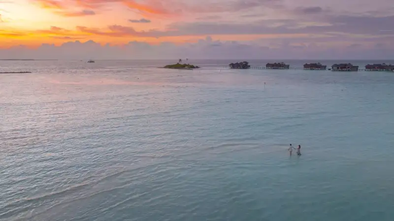 Digital nomad working on a laptop in an overwater bungalow