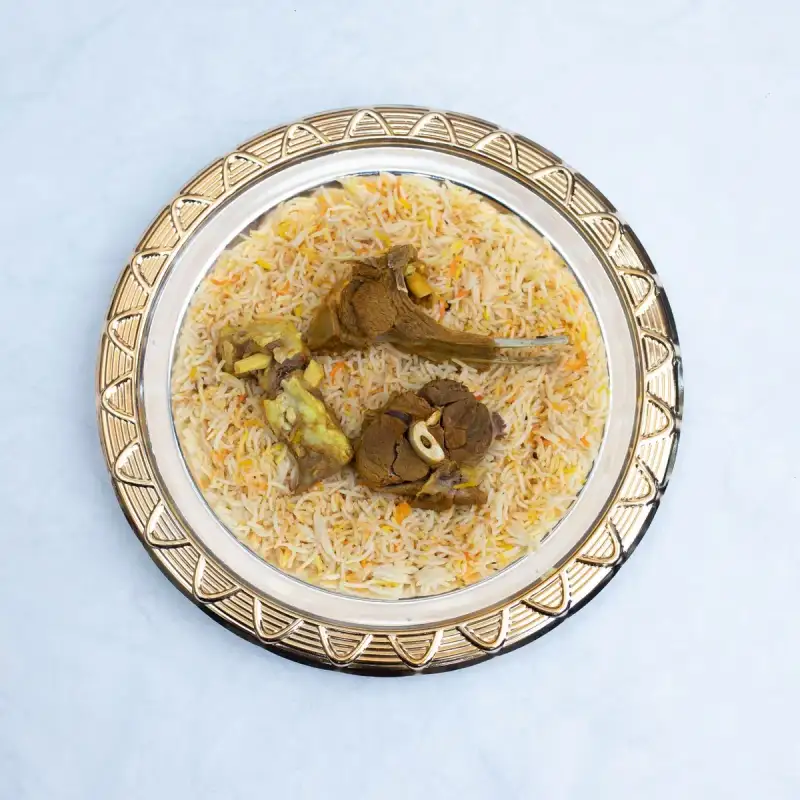 Marinated meat for biryani in a copper bowl