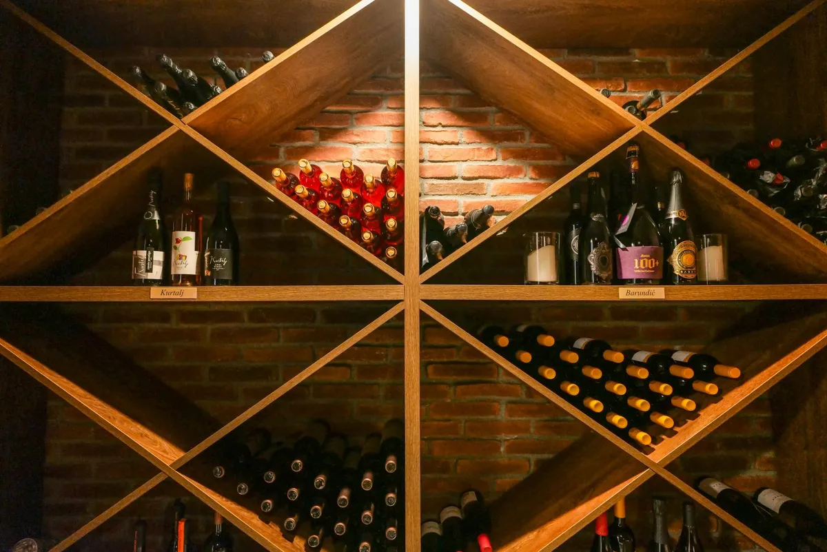 An atmospheric view of a stone-vaulted wine cellar hidden beneath a castle