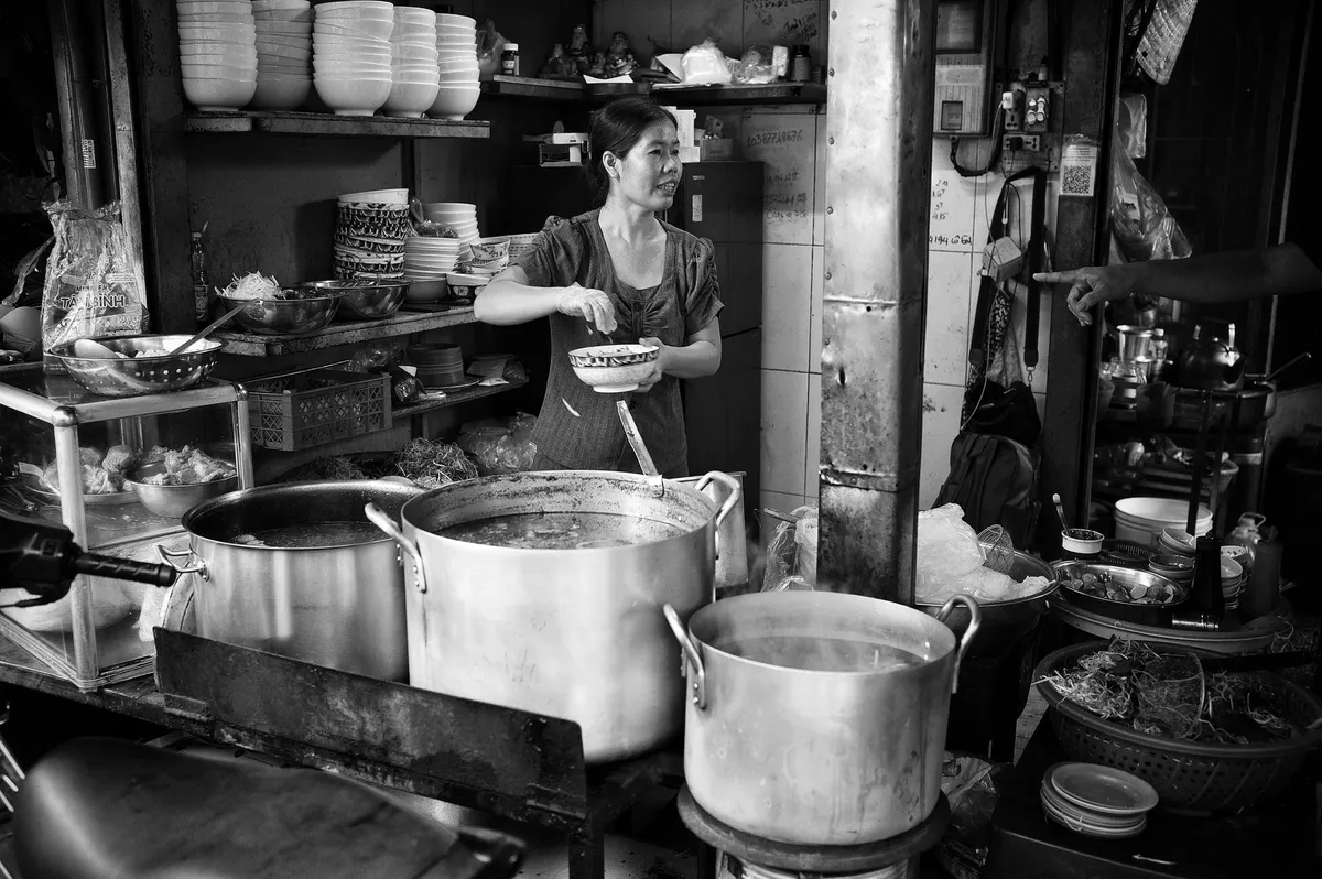 Hanoi street food vendor cooking pho