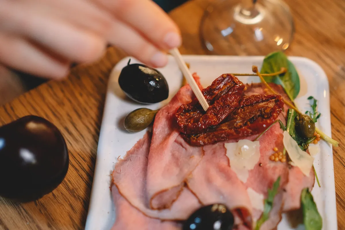 A glass of red wine next to a plate of tapas