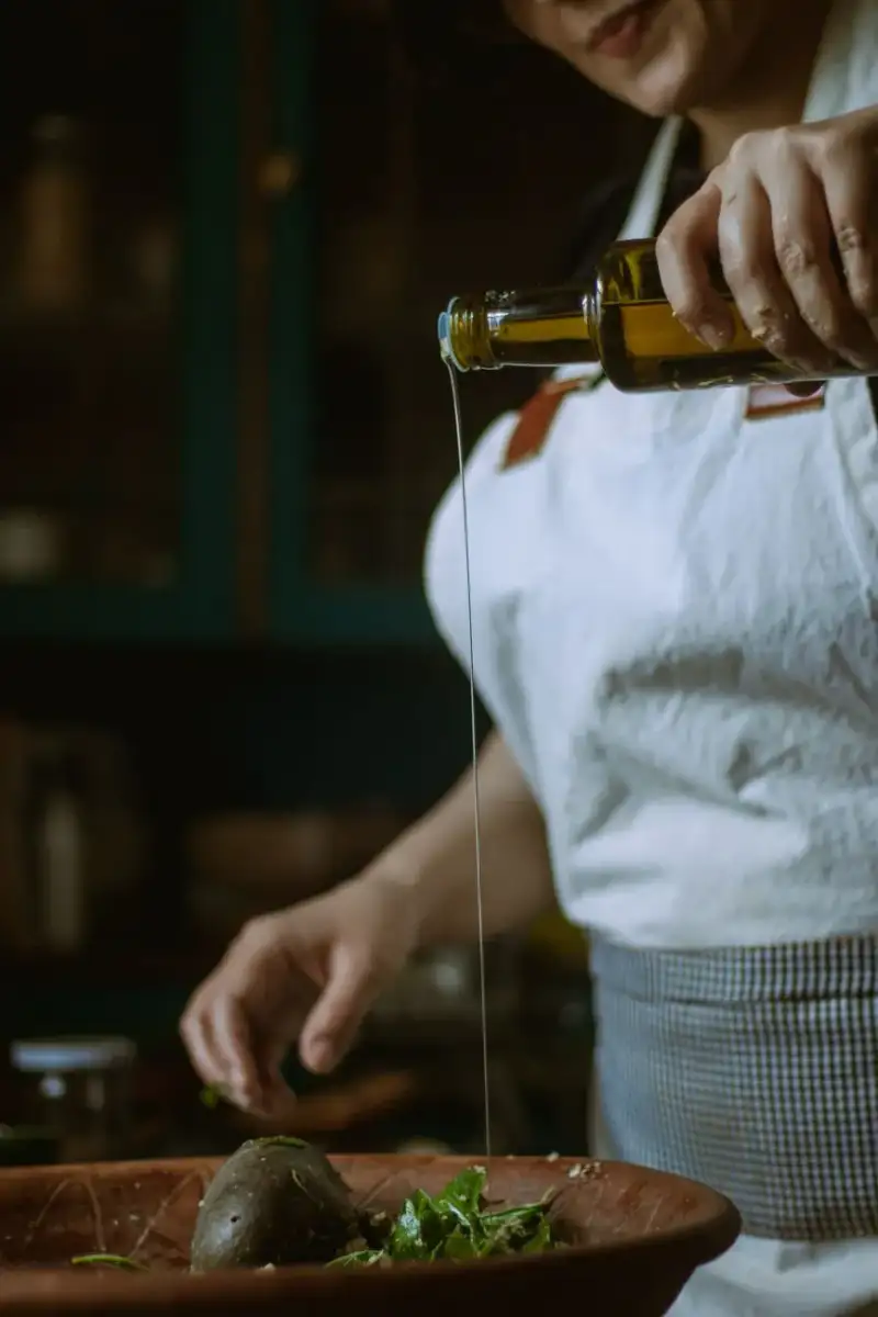 Drizzling olive oil over fresh ingredients