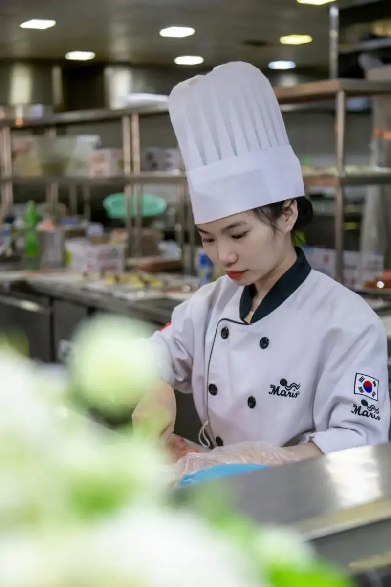 A molecular model of glutamate, the key compound behind umami, with a chef in the background preparing a dish