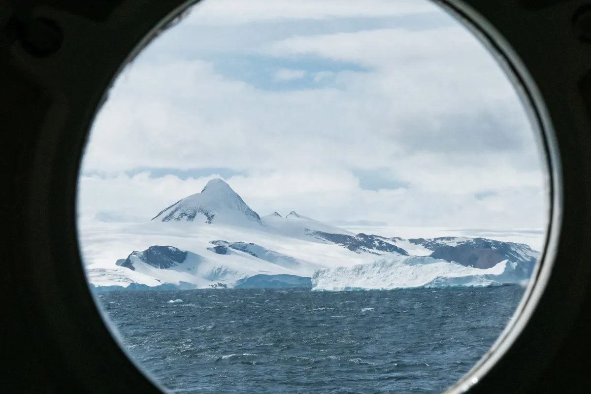 Large expedition cruise ship anchored near Antarctic peninsula