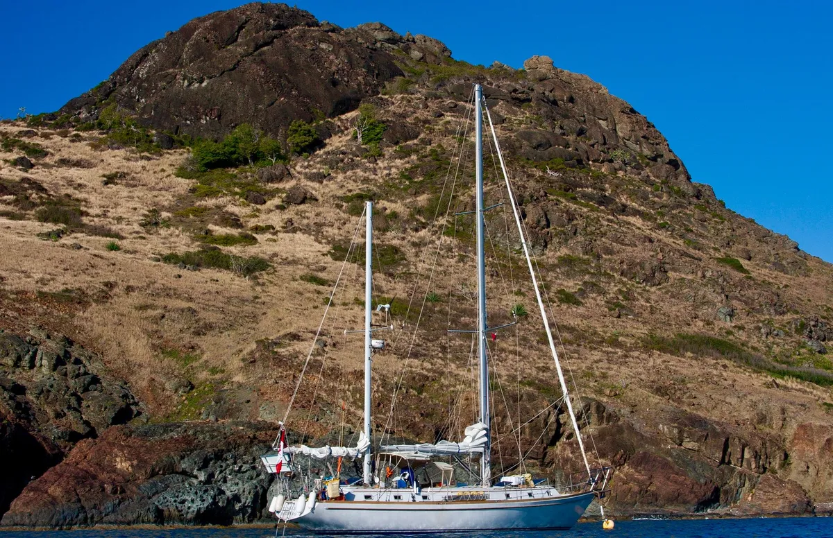 Sailing yacht anchored in Antarctic bay near icebergs