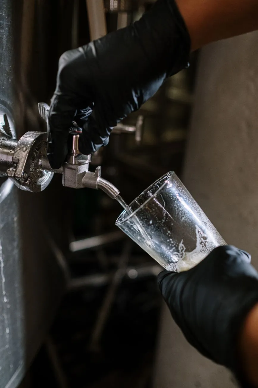 A home brewer carefully pouring wort into a fermentation vessel