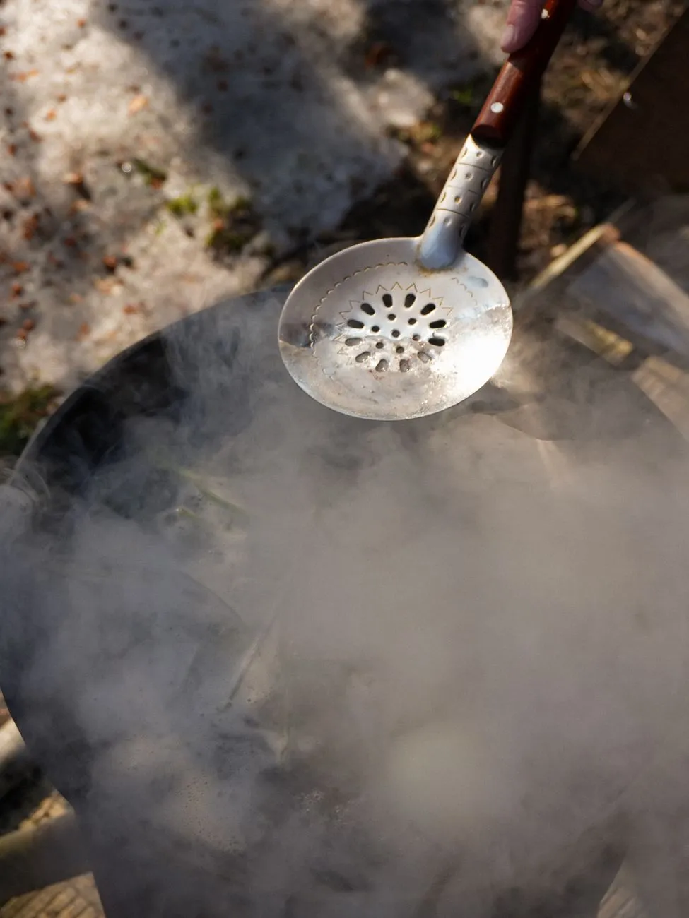 A close-up of hops being added to a boiling wort