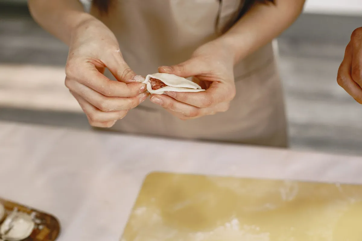Pierogi being filled with a sweet filling