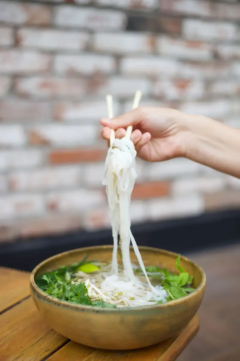 A bowl of southern pho with bean sprouts and herbs