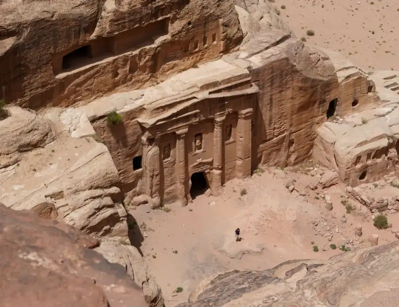 Panoramic view of Petra's ancient city with various rock-cut tombs and sandstone structures in a vast valley